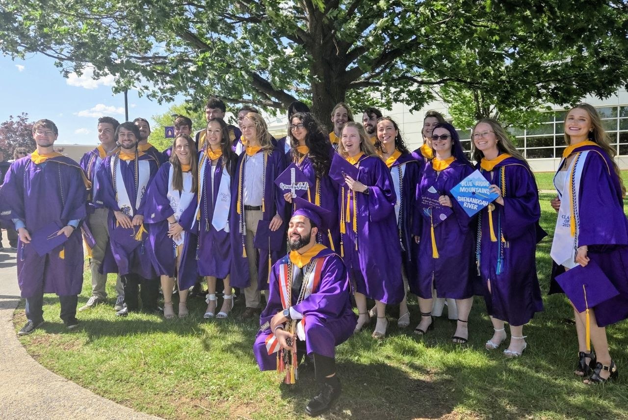 JMU Chemistry Class of 2025 graduates gathered outdoors in purple regalia